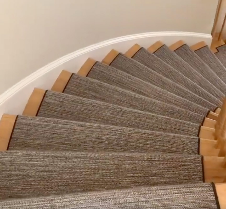 Black and white custom stair runner on curved stairs installed by Farsh Carpets and Rugs